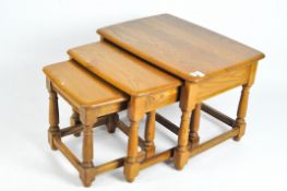 A nest of three Ercol occasional tables, of rectangular form, on turned legs,