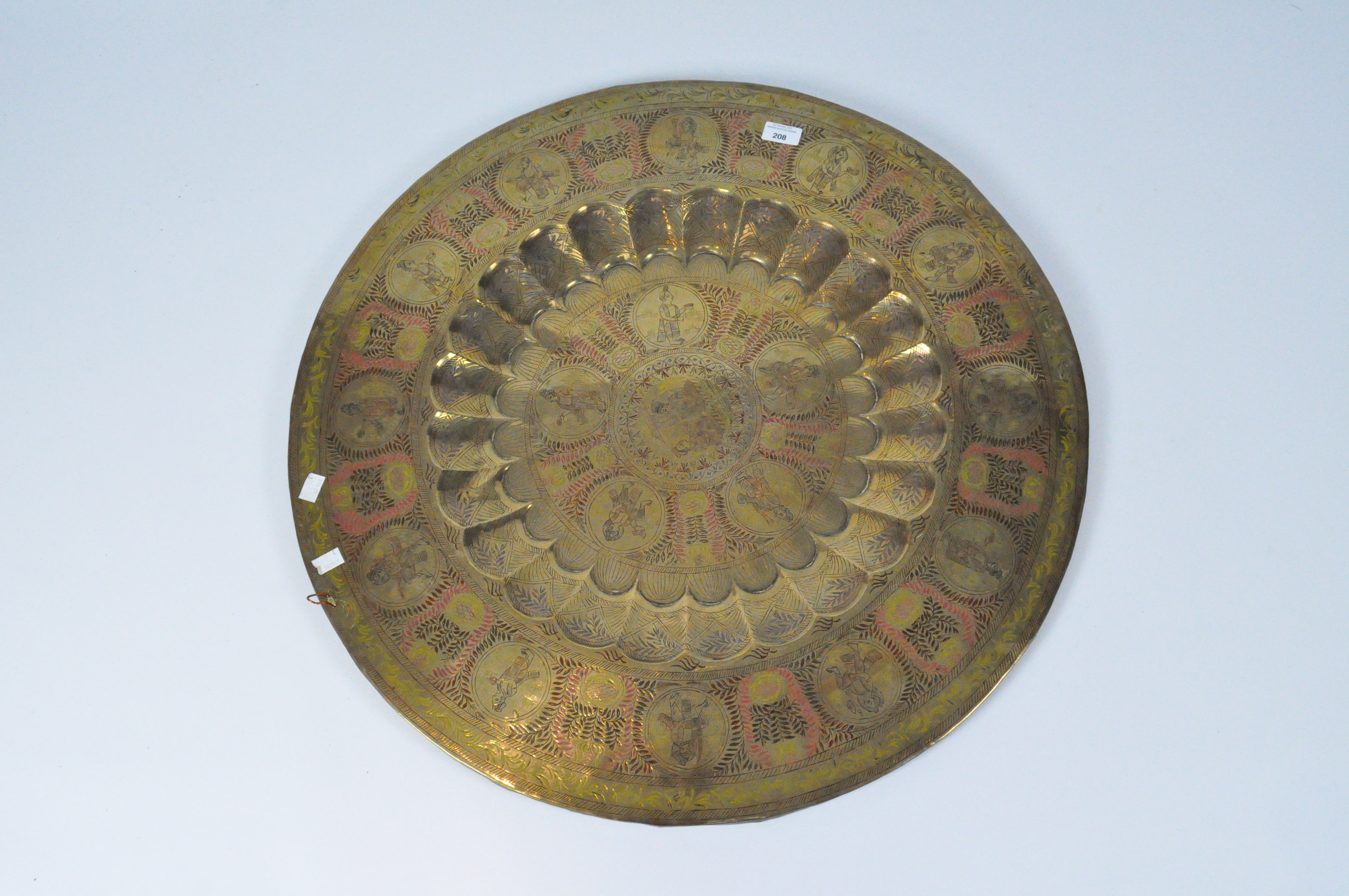 A Persian style brass table top or charger, engraved with figures and leaves,