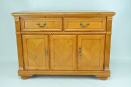 A contemporary pine sideboard, two panelled drawers above two doors, with bobbin turned detail,