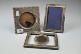 Three silver mounted photo frames, one decorated with floral and bark effect motifs,