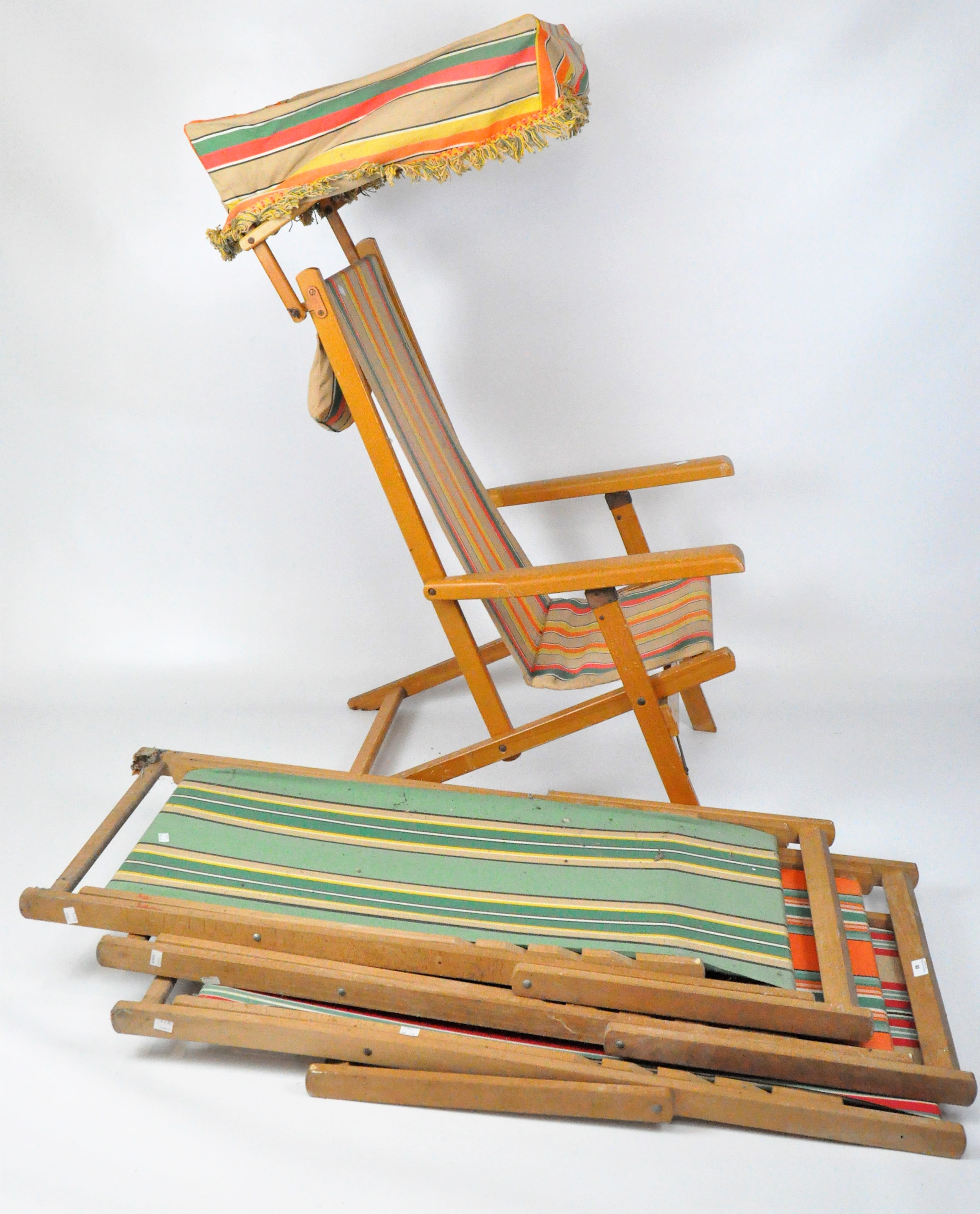 Three folding deck chairs together with a deck chair canopy, with wooden frames,