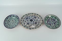 Three Middle Eastern plates and bowls, in blue, green and white glaze with floral decoration,
