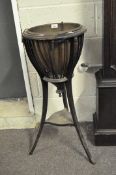 An Edwardian mahogany circular jardiniere, with carved lions head details, with brass liner,