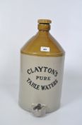 A large stoneware water dispenser labelled Clayton's Pure Table Waters