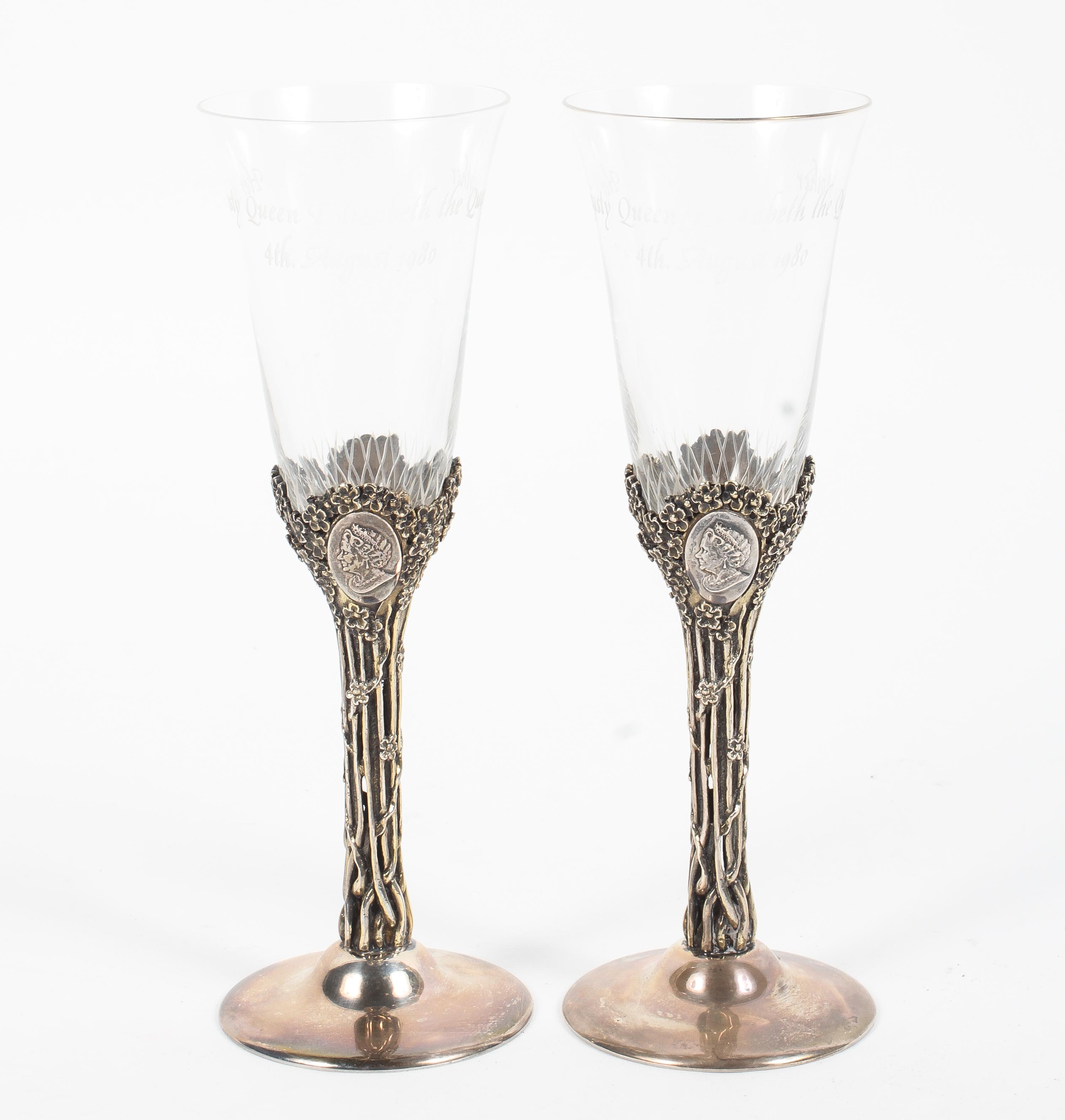 A pair of sterling silver and engraved glass wine glasses,