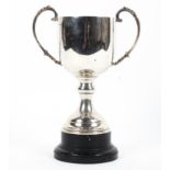 A sterling silver trophy with loop handles on a circular stepped base. with turned ebonised stand.
