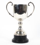 A sterling silver trophy with loop handles on a circular stepped base. with turned ebonised stand.