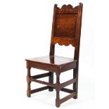 A 19th century oak hall chair, with scrolled top rail and solid panelled back and seat,