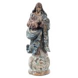 A carved wooden religious figure, modelled standing with hands clasped in prayer,
