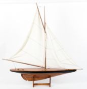 A Nauticalia wooden model of a yacht on stand, with white cotton sails,