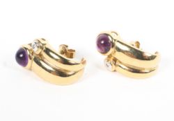 A pair of unmarked yellow metal earrings each set with round cabochon amethysts. 7g.