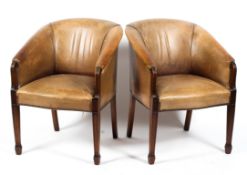 Two brown leather style studded tub armchairs, on reeded tapering legs,