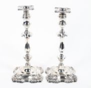 A pair of sterling silver Georgian style candlesticks on square loaded bases.