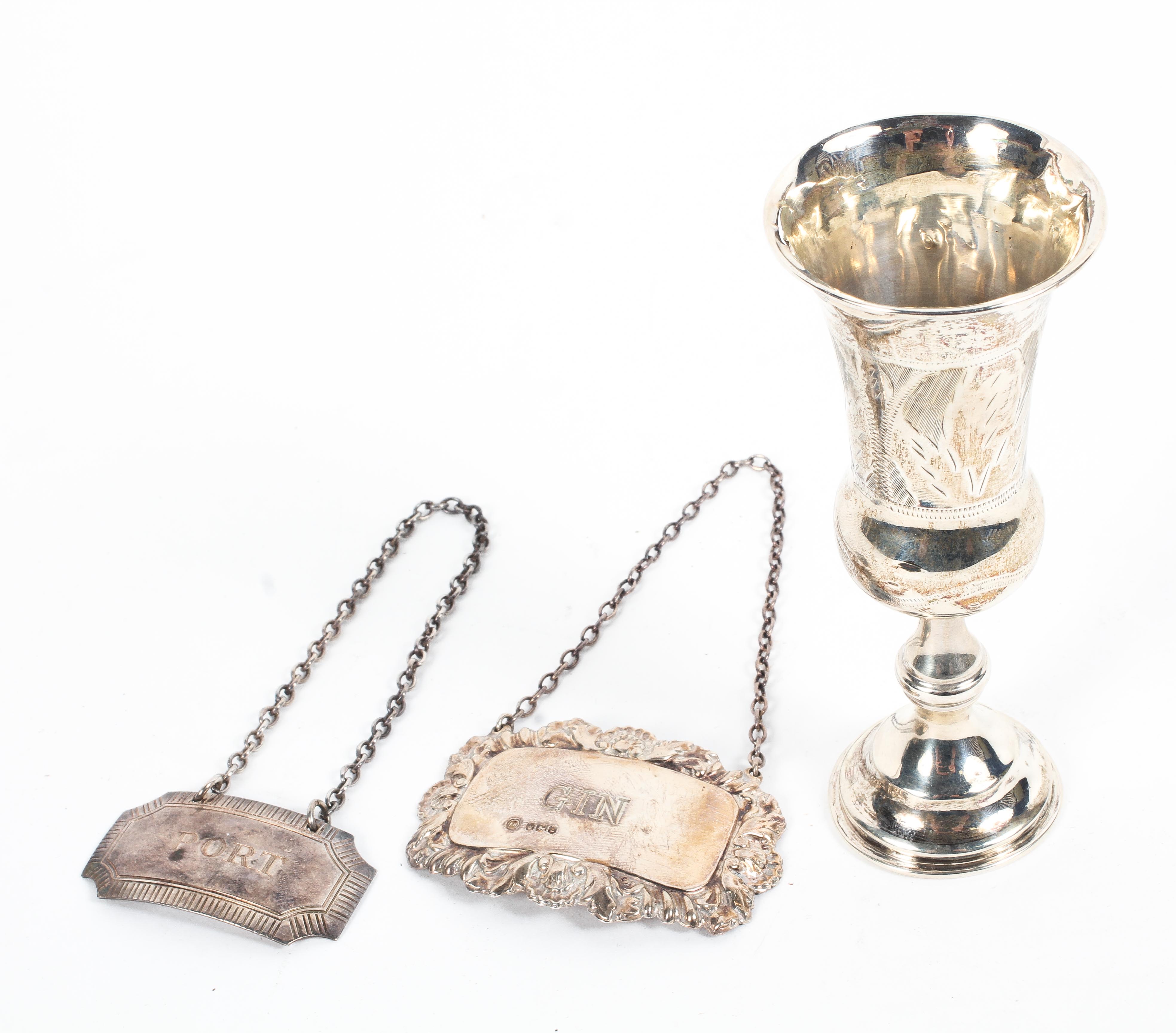 Two sterling silver decanter labels together with a small sterling silver communion cup,