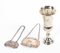 Two sterling silver decanter labels together with a small sterling silver communion cup,