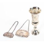 Two sterling silver decanter labels together with a small sterling silver communion cup,