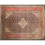 A North West Persian Ardabil style wool rug, red ground with central geometric medallion.