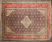 A North West Persian Ardabil style wool rug, red ground with central geometric medallion.