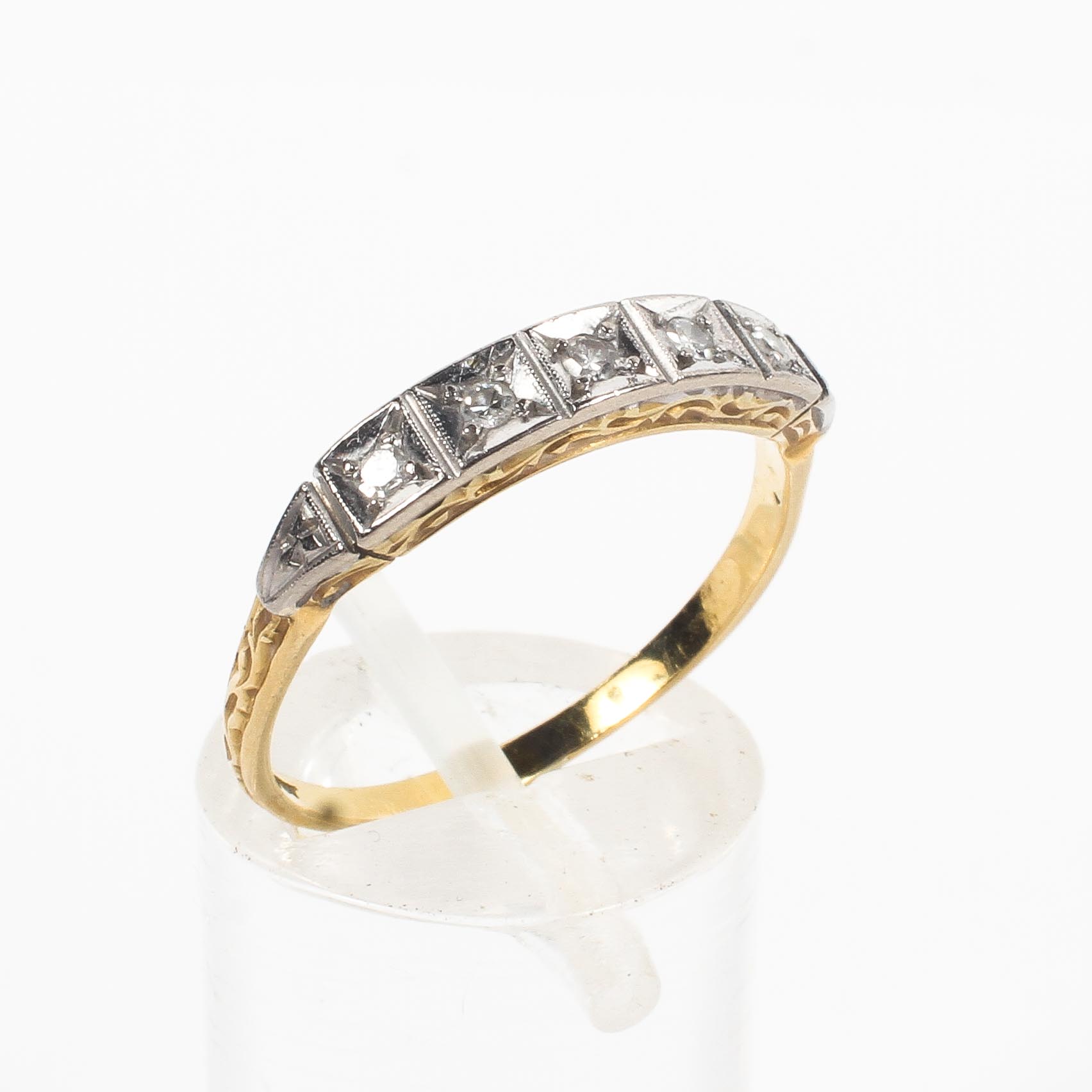 A yellow and white metal ring set with single cut diamonds estimated to weigh a total of 0.05cts.