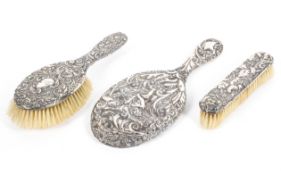 A sterling silver backed brush set with raised acanthas leaf decoration.