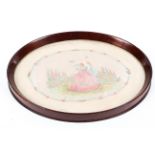 An Edwardian mahogany oval tray inset with silk embroidered picture of Watteauesque figures in a