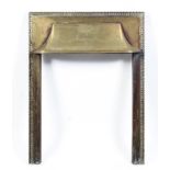 An Edwardian brass fire surround, incised with neo-classical ribboned urn and stiff leaf border,