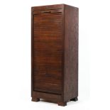 A stained oak tambour fronted cabinet, early 20th century, enclosing eight sliding drawers,