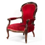 A Victorian style carved walnut armchair, upholstered in cherry coloured velvet to seat,