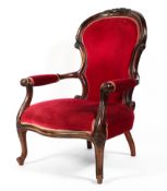 A Victorian style carved walnut armchair, upholstered in cherry coloured velvet to seat,