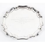 A sterling silver salver or card tray with pie crust border raised on three scrolling feet by Atkin