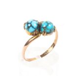 A 9ct rose gold crossover ring set with two turquoise cabochons. 1.5g. Size O.