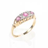 A 9ct gold ruby and diamond ring set with three free cut rubies with single cut diamond accents. 1.
