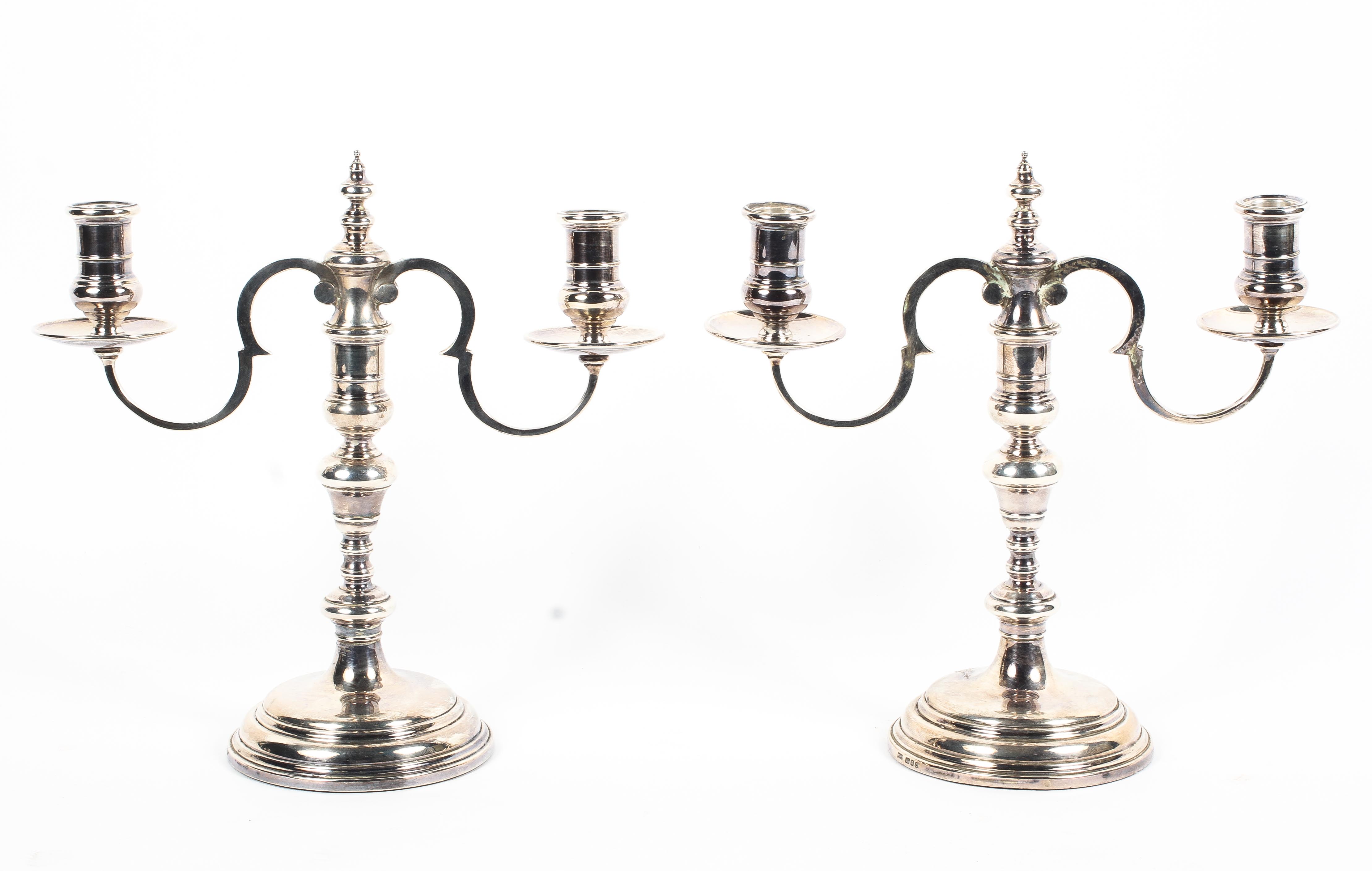 A pair of sterling silver two branch candelabra with loaded bases. by Courtman Silver London 1976.