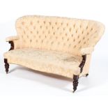 A Victorian button back settee, of serpentine form with scroll carved arms and foliate carved legs,