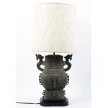 A Chinese simulated archatic-style simulated bronze table lamp, cast with symbols and scrolls,