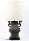 A Chinese simulated archatic-style simulated bronze table lamp, cast with symbols and scrolls,