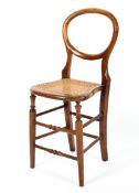 A 19th century mahogany and oak caned child's chair, with balloon back,