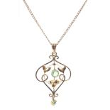 An Art Nouveau yellow metal and peridot set openwork pendant on yellow metal curb link chain.