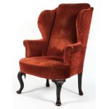 A Georgian style wing back armchair, upholstered in pale red fabric,