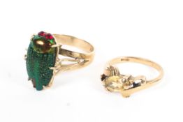 Two 9ct gold rings, an enamelled scarab beetle together with a single stone citrine quartz ring,