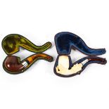 A carved meerschaum pipe and a wooden example, the first carved with a hand holding the bowl, cased,