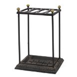 A late 19th century wrought and cast iron stick stand, with brass finials and four ovolo apertures,