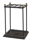 A late 19th century wrought and cast iron stick stand, with brass finials and four ovolo apertures,
