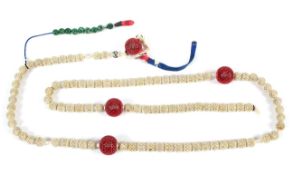 A carved and stained ivory ball necklace, late 19th/early 20th century,