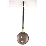 A vintage brass bed pan with wooden handle,