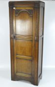 A mid 20th century oak wardrobe, carved decoration to the front panel, small metal handle,