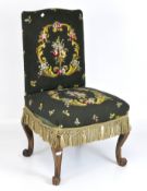An early 20th Century chair, in green upholstery decorated with scrolls and flowers,