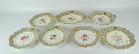 Six Victorian Rococo style plates and a serving platter, all with scrolling edges,