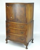 A reproduction bow fronted walnut tallboy, a double door cupboard above three long drawers,