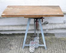 A child's work table with wooden top, the blue metal under-frame and pedals marked 'Hobbies',